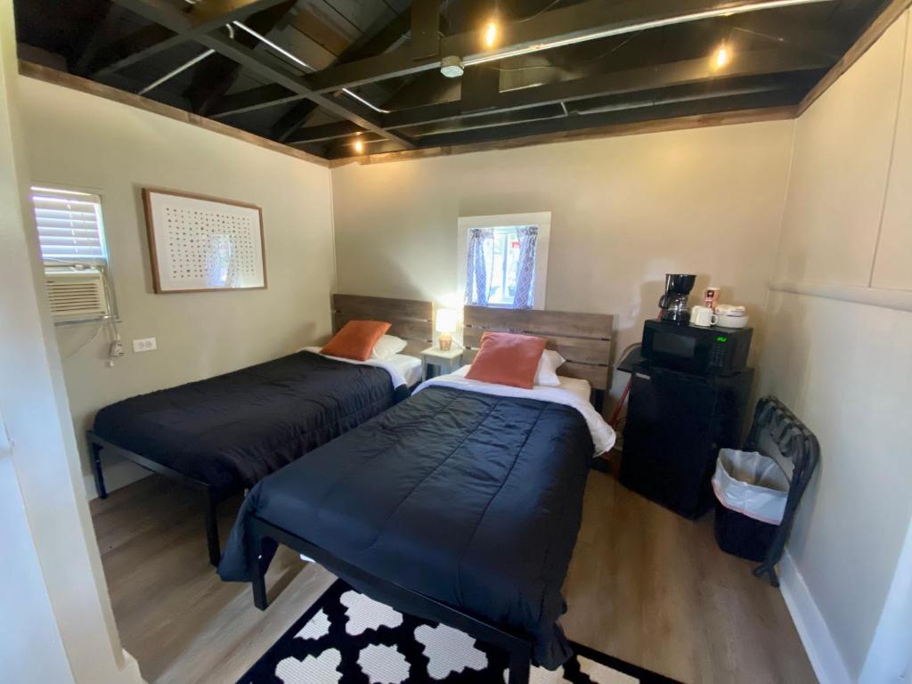 a room with two beds and a table in it at Cabin 9 at Horse Creek Resort in Rapid City