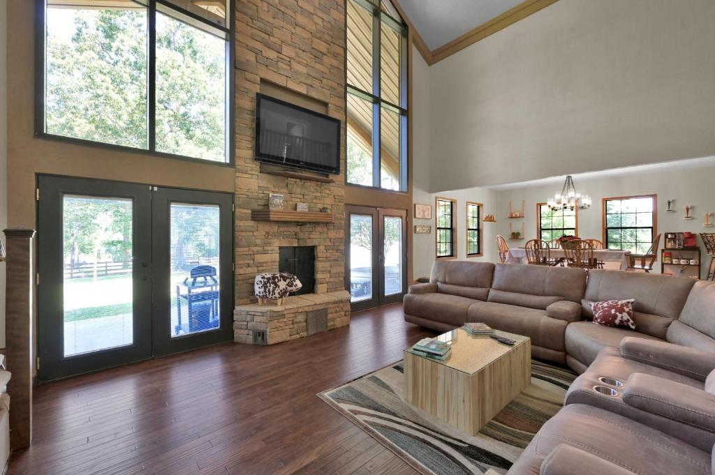 a living room with a couch and a fireplace at Massive Texas Ranch House By Lake and Forest in Coldspring