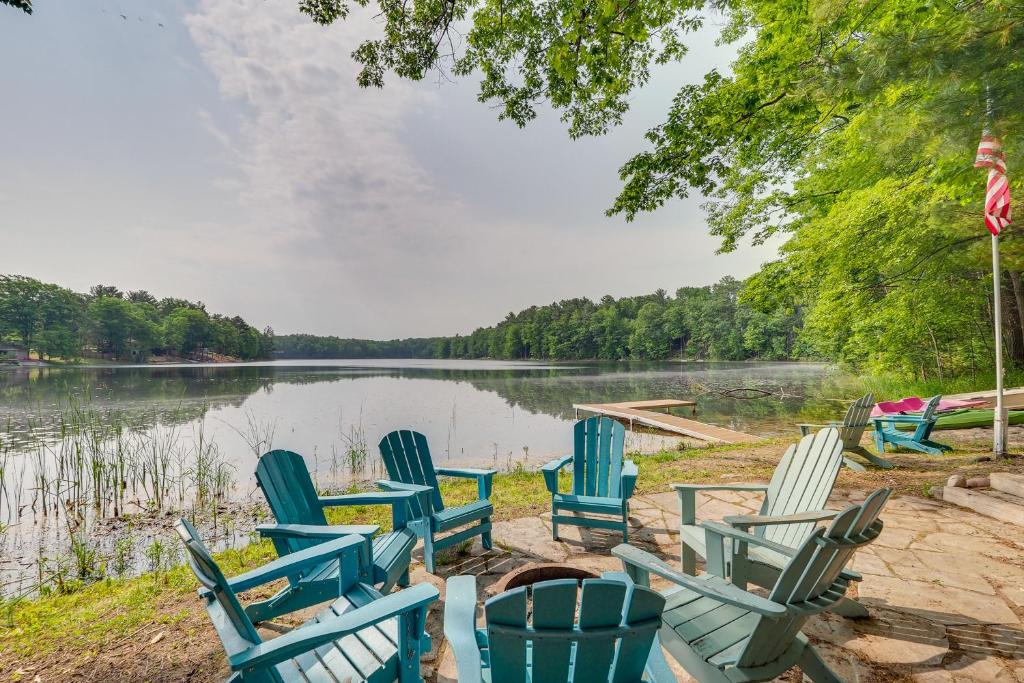 a group of chairs sitting on the shore of a lake at Traverse City Retreat with Deck and Lake Access in Traverse City