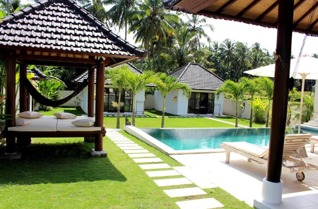 a resort with a pool and a gazebo at Uma Kama Villa in Ubud
