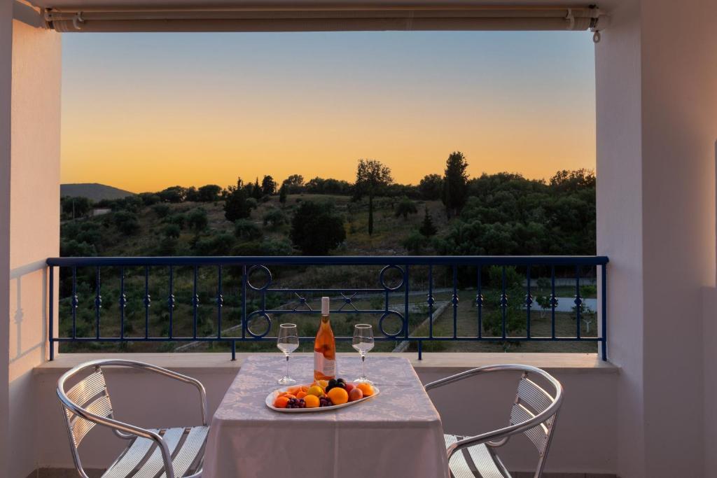 a table with wine glasses and a bowl of fruit on a balcony at Villa Rodanthi Sivota in Syvota