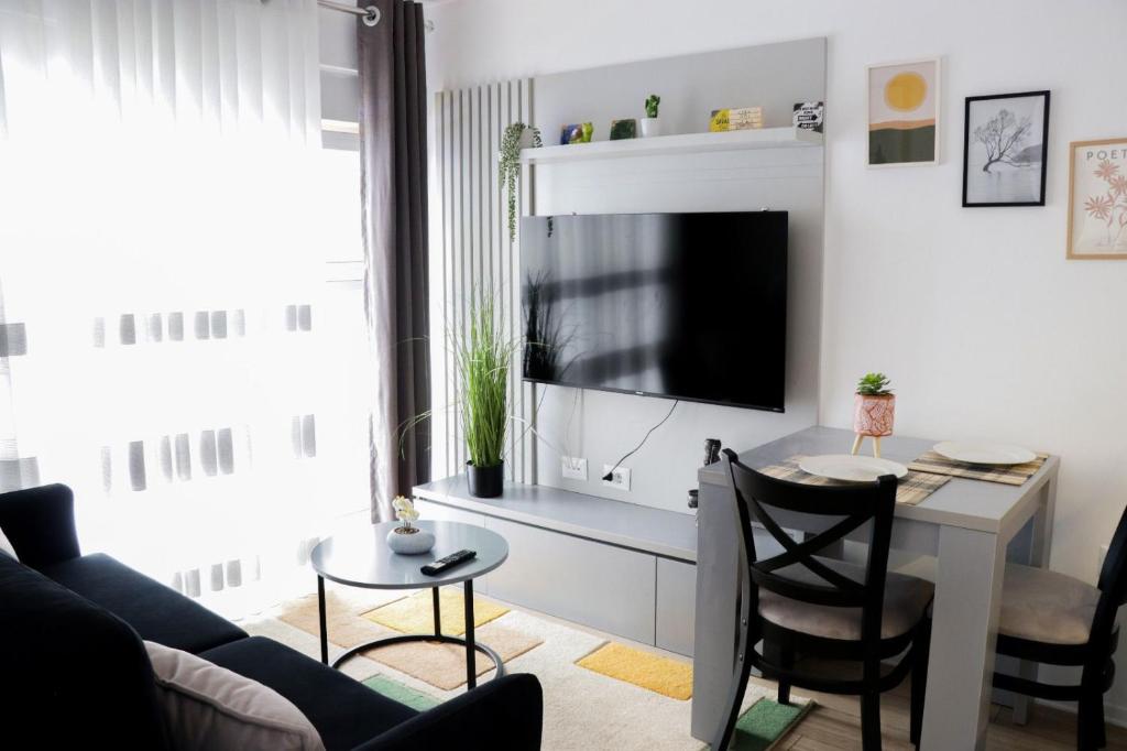 uma sala de estar com uma mesa e uma televisão em Comfy Studio at 'Mangalem21 Complex' Parking-WiFi-AC-View em Tirana