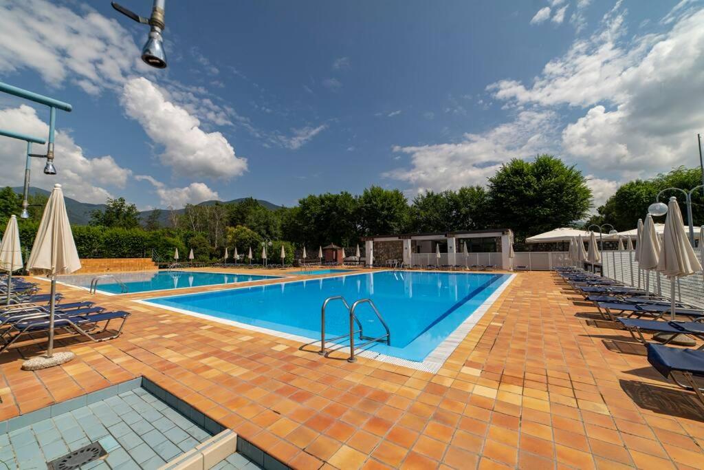 a large swimming pool with chairs at Patio 15 - Pools, tennis and water sports in Iseo