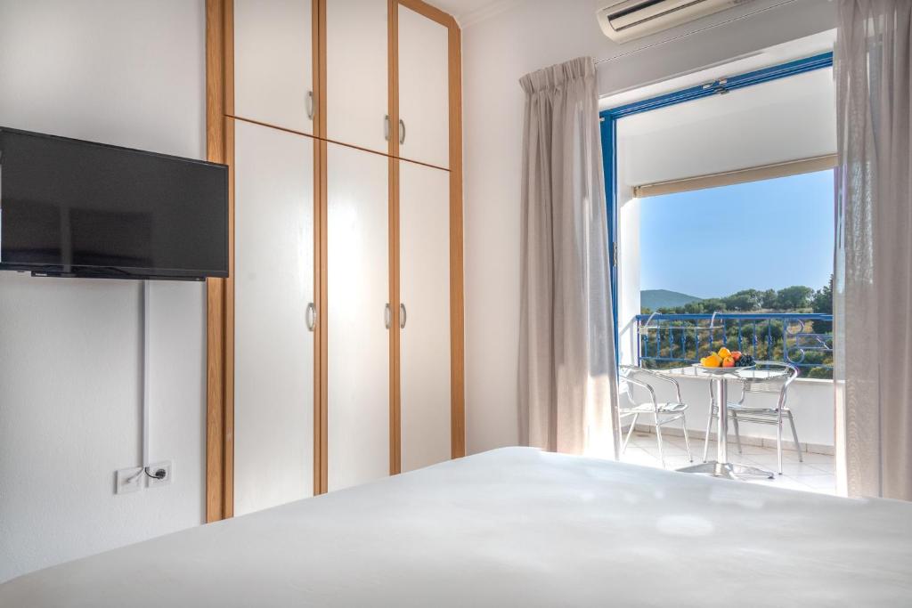 a bedroom with a bed and a window with a table at Villa Rodanthi Sivota in Sivota