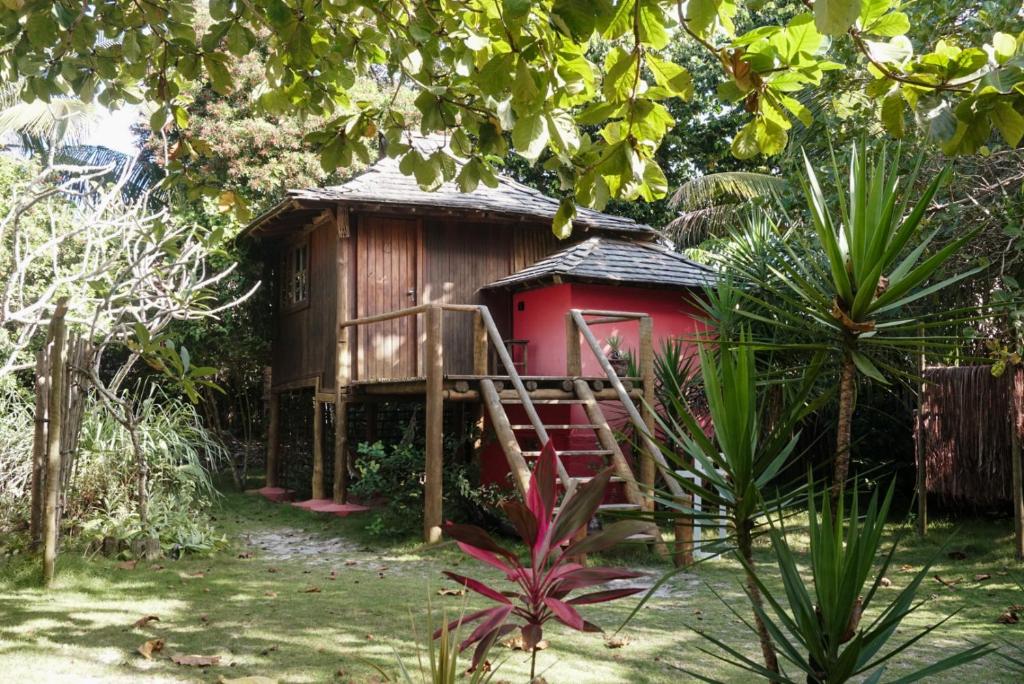 a small red house with a staircase in front of it at Bangalôs da Aldeia Caraiva in Caraíva