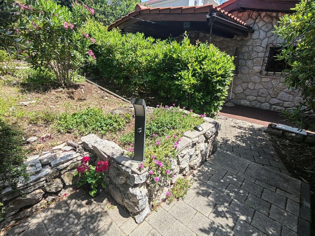 a garden with a stone wall and some flowers at Apartment Lada in Dramalj