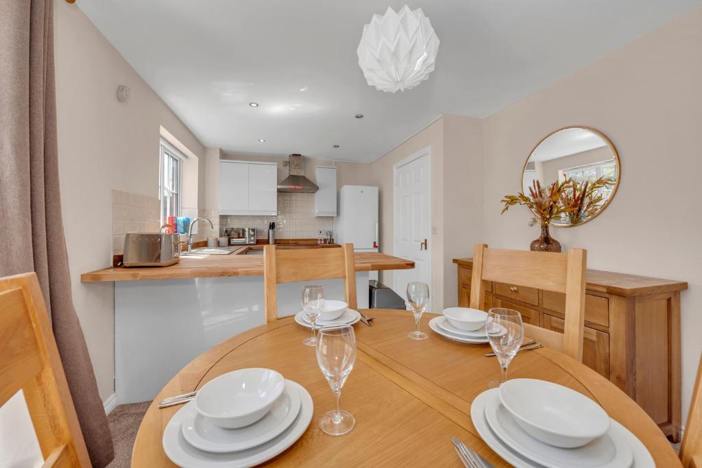 uma sala de jantar e cozinha com mesa e cadeiras de madeira em The Grange Luxe3 em Ipswich