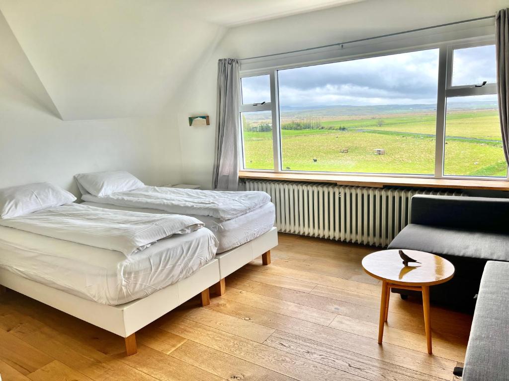 1 dormitorio con cama, ventana y sofá en Mengi Countryside, en Kjarnholt