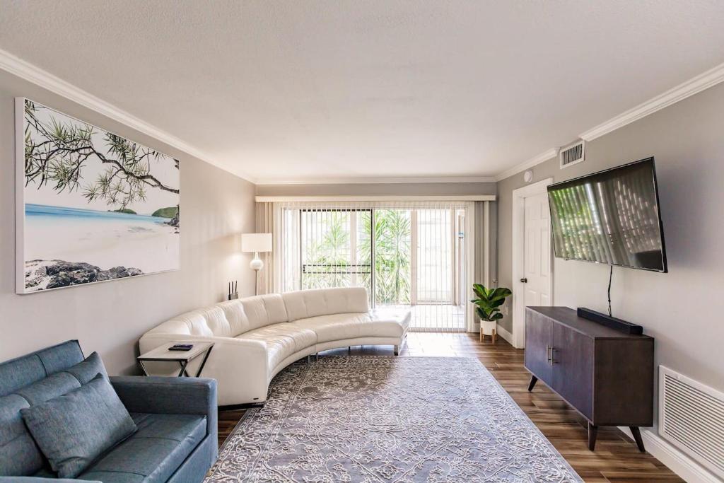 a living room with a couch and a tv at Bright 2 bedroom 2 bath condo with pool in Sarasota