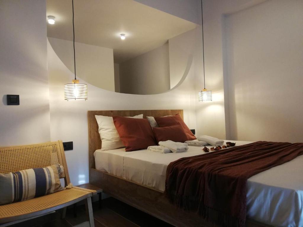 a bedroom with a bed with a mirror on the wall at Simά Apartments in Heraklio Town