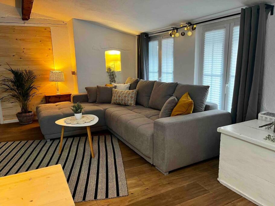 ein Wohnzimmer mit einem grauen Sofa und einem Tisch in der Unterkunft Ferienhaus „große Familie“ in Zülpich