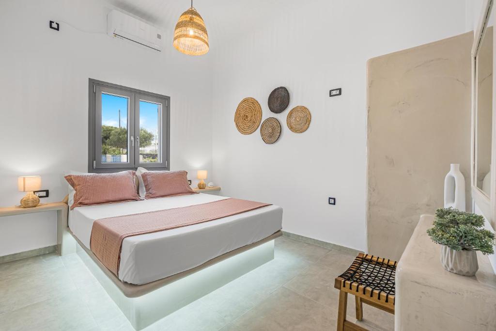 Habitación blanca con cama y ventana en Zana's Villas-Zenia, en Akrotiri