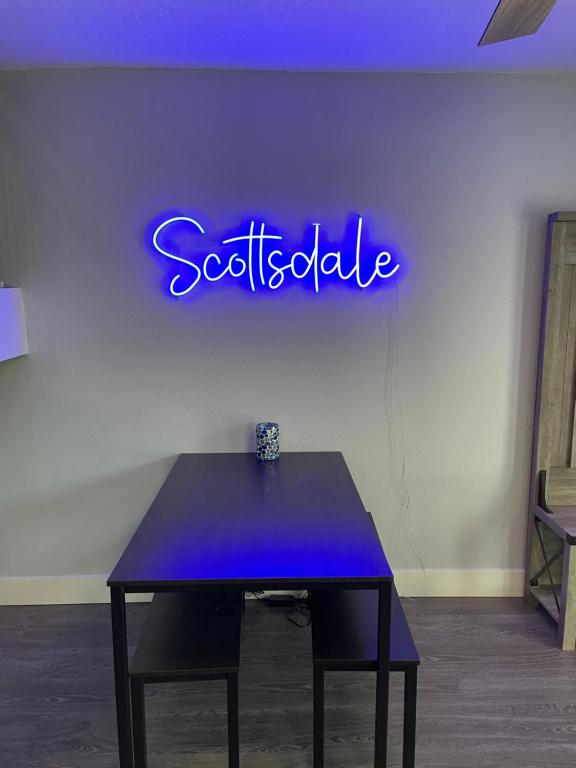 Niebieski neon na ścianie ze stołem w obiekcie Desert Palms Hangout w mieście Scottsdale