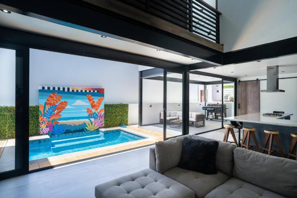 Una sala de estar con un sofá y una piscina. en Casa Alvana - Sauna & Private Pool, en Ensenada