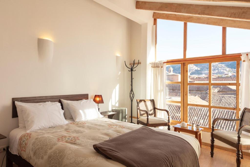 a bedroom with a bed and a large window at SAMANA B&B in Cusco