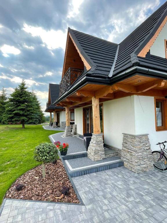 a house with a patio and a roof at Stylove Domki Bańska Niżna Domki z Jacuzzi in Bańska Niżna