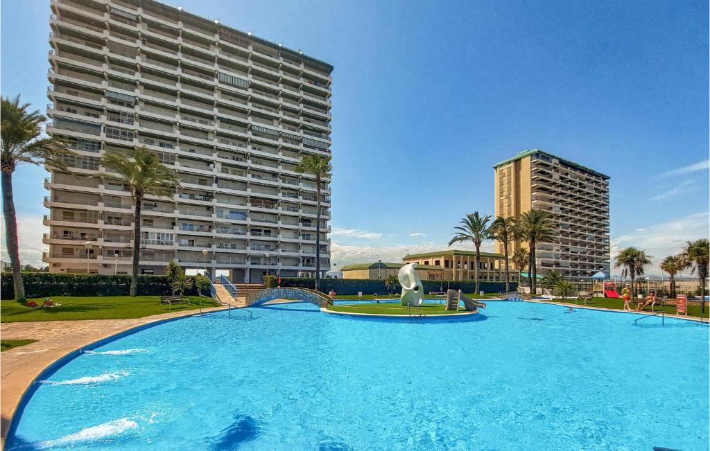 a large swimming pool in front of a large building at Amazing Apartment In El Puig De Santa Maria With Kitchen in La Torre