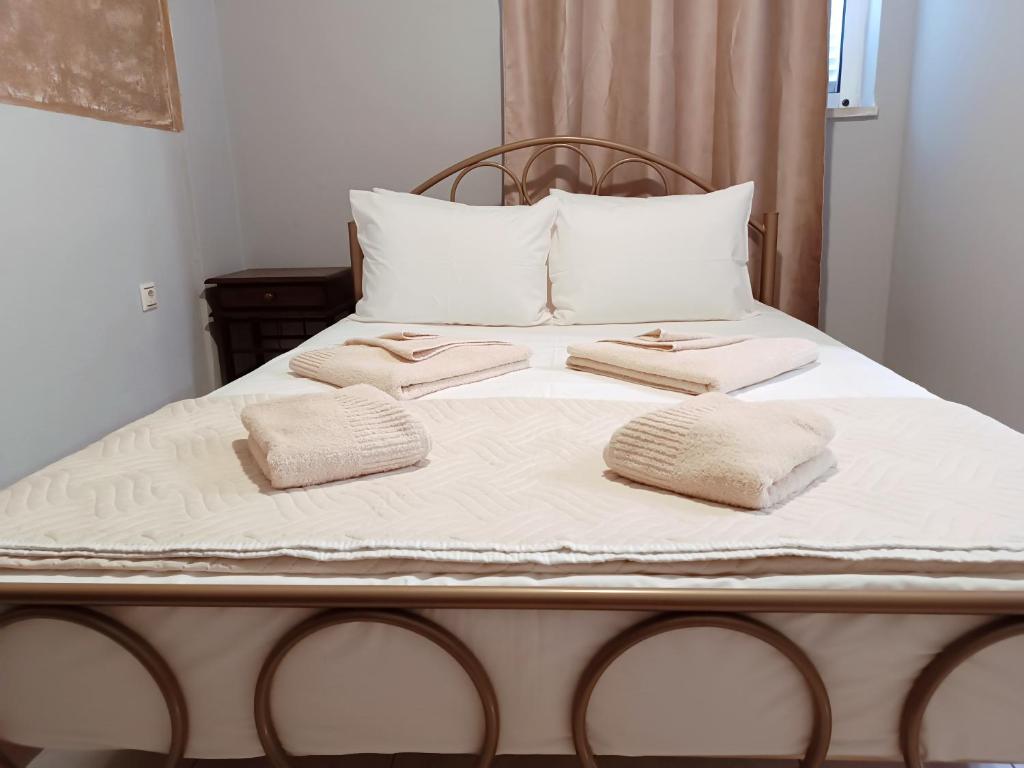 A bed or beds in a room at Aphrodite accommodations