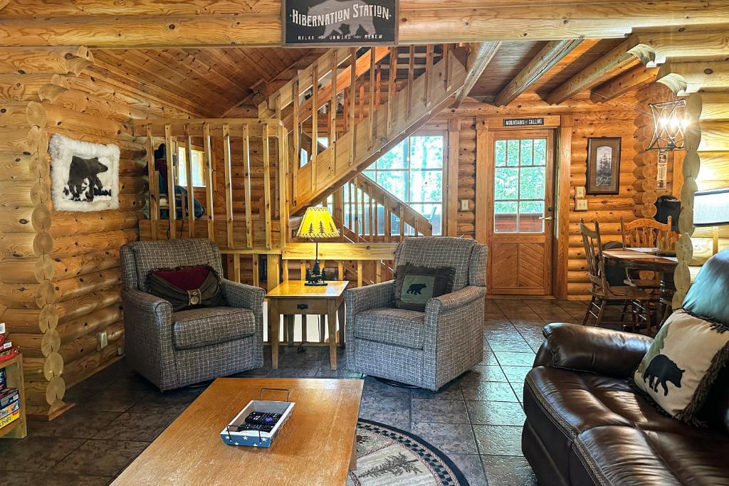 uma sala de estar com sofás e uma mesa num chalé de madeira em Pine Cone Cabin em Gatlinburg