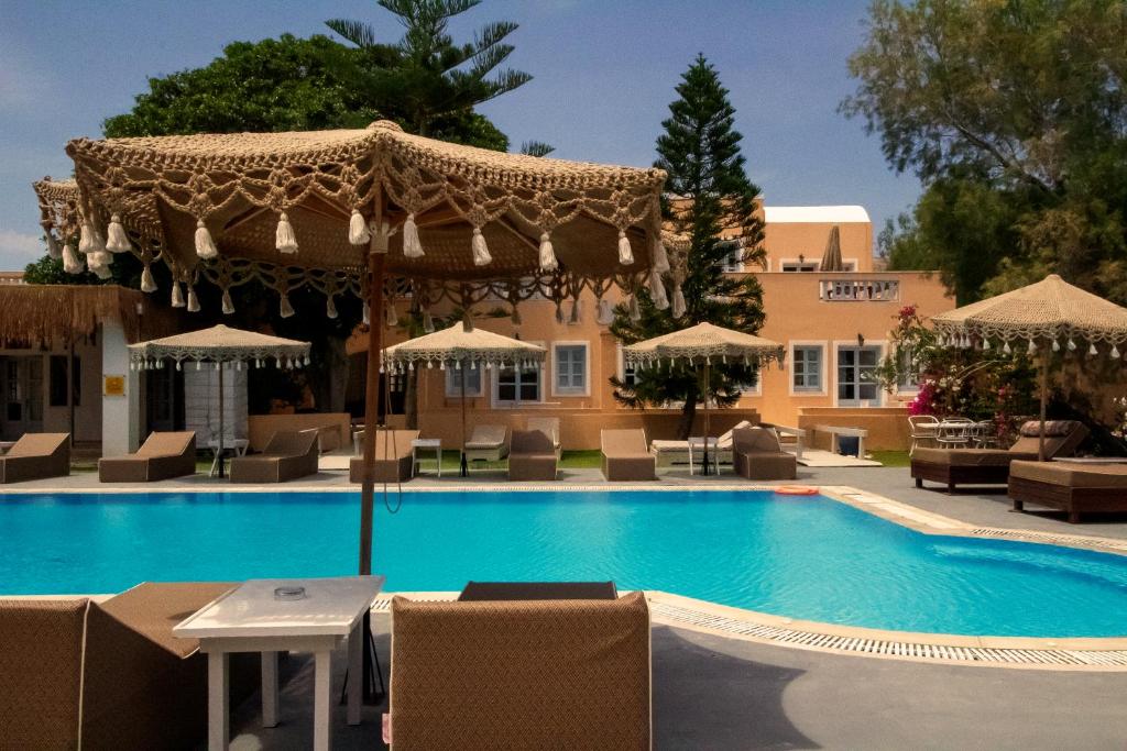 een zwembad met stoelen en parasols naast een hotel bij Joy Beach Ηotel in Perivolos