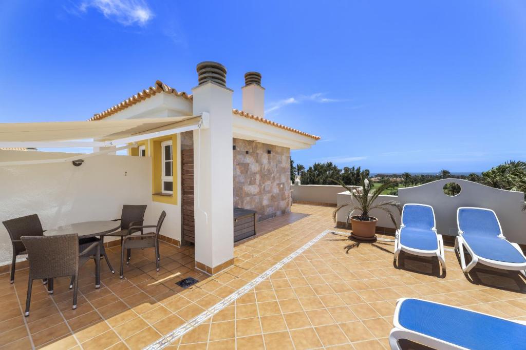 a patio with a table and chairs and a house at Casahost Fuerteventura Golf in La Guirra