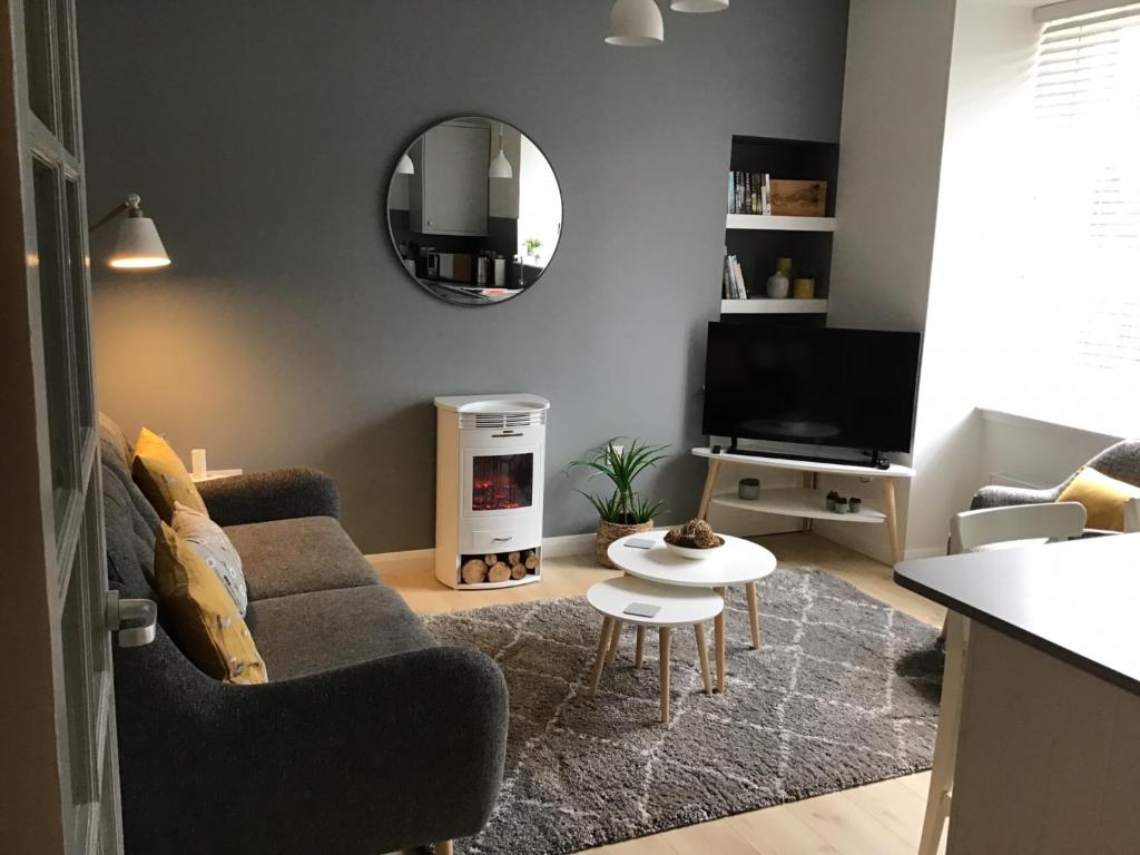 a living room with a couch and a mirror at 5a Plantation Road in Stornoway