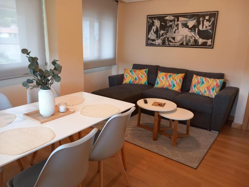 a living room with a couch and a table and chairs at Apartamento Aurora in Villaviciosa