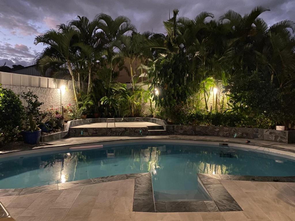 a swimming pool in a yard at night at Chambres d'hôtes du domaine des doudous in Saint-Pierre
