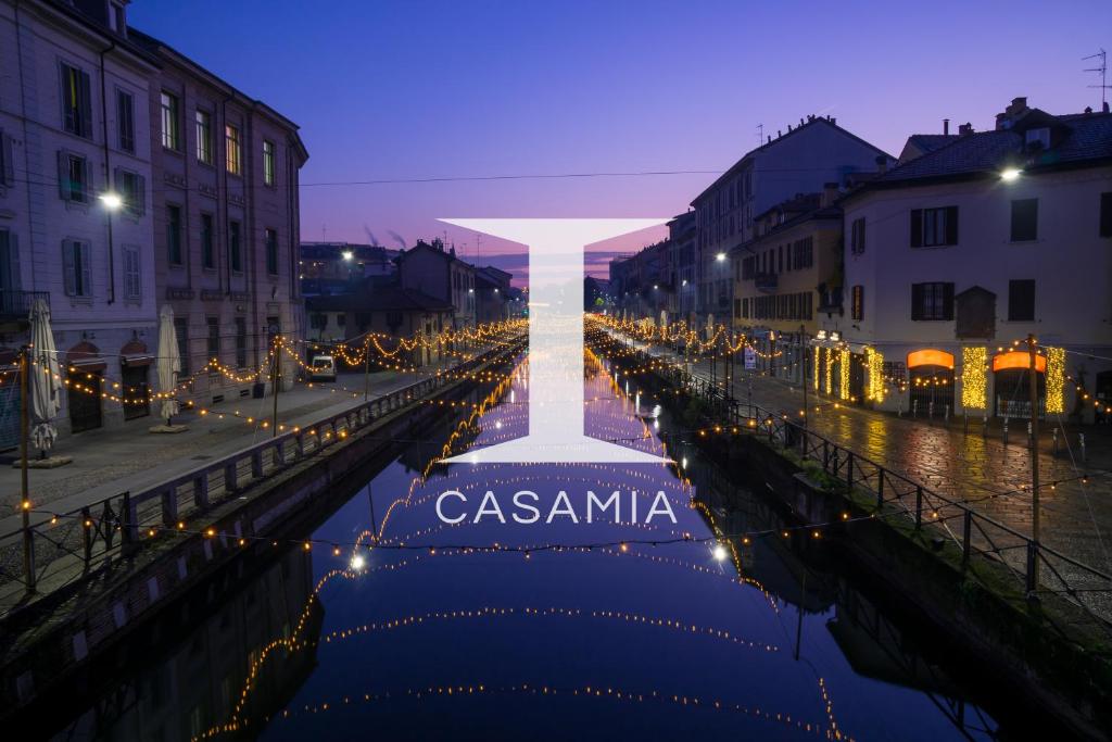 una croce su un canale di notte con luci di Suite Alzaia by iCasamia a Milano