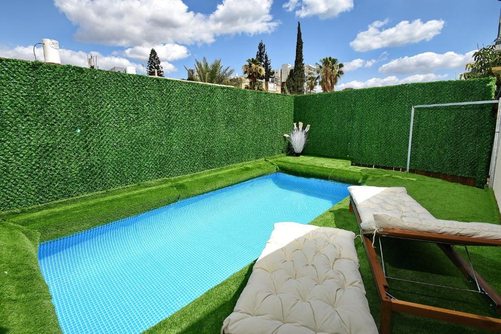 a swimming pool in a garden with a fence at Levication 2 bedrooms Pool&jacuzzi in Tiberias