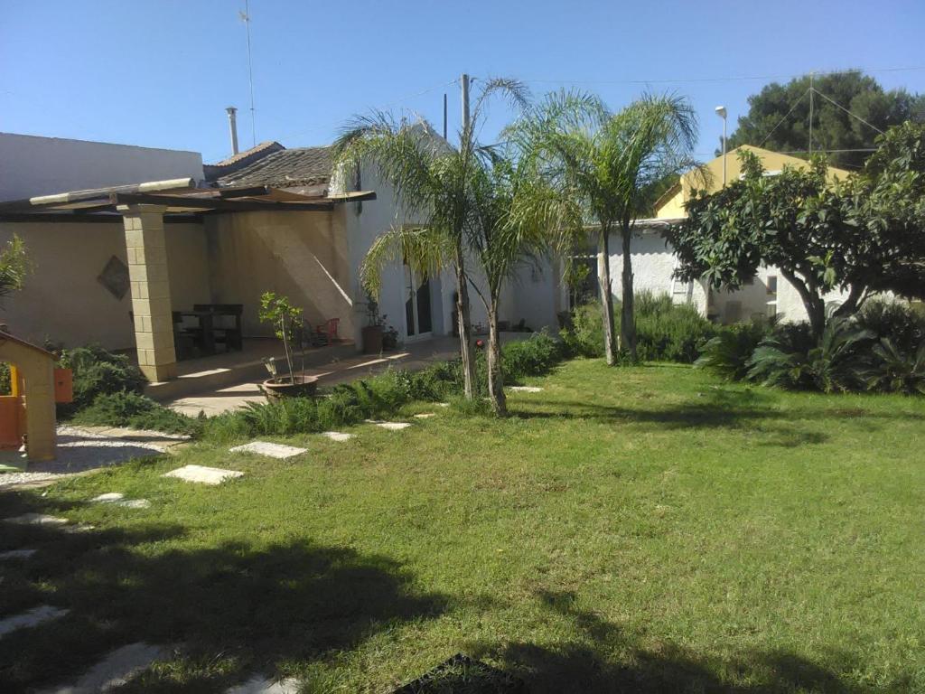 einen Hof mit Palmen und einem Haus in der Unterkunft Demetria Beach House in Marsala