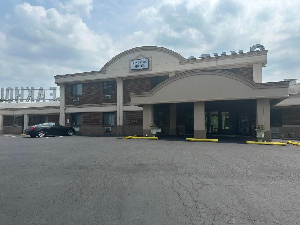 a building with a car parked in a parking lot at Kingston Motel in Kingston