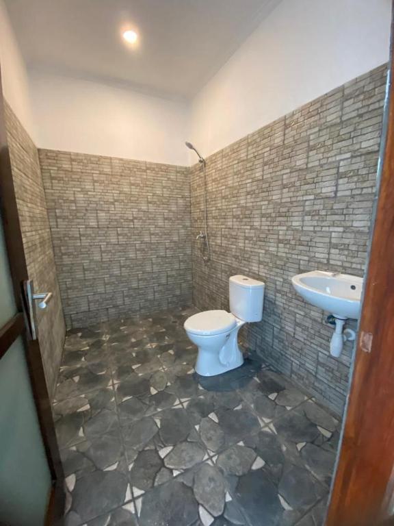 a bathroom with a toilet and a sink at New Anugrah Hotel in Teluk Nara