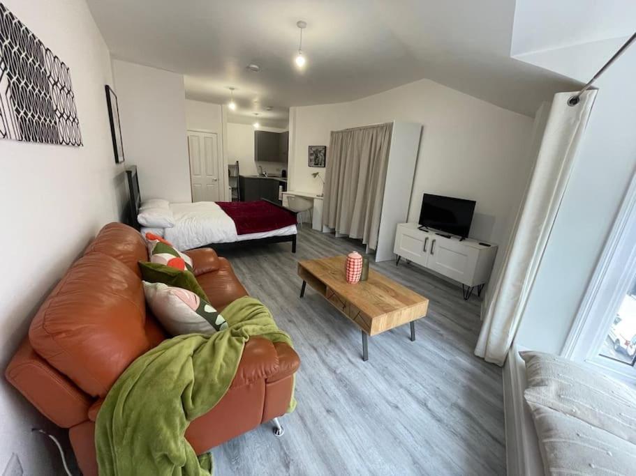 een woonkamer met een bank en een bed bij Stunning Central Woking Studio in Woking