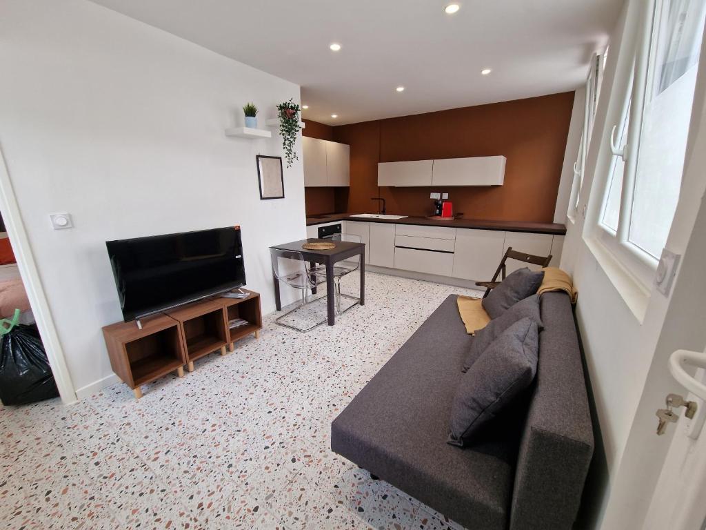 a living room with a couch and a flat screen tv at maison PING ,en face des arènes in Béziers