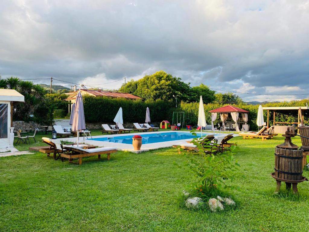 una piscina en un patio con sillas y sombrillas en THE MANSION OF DIONISOS AND DIMITRAS 2, en Olimpia