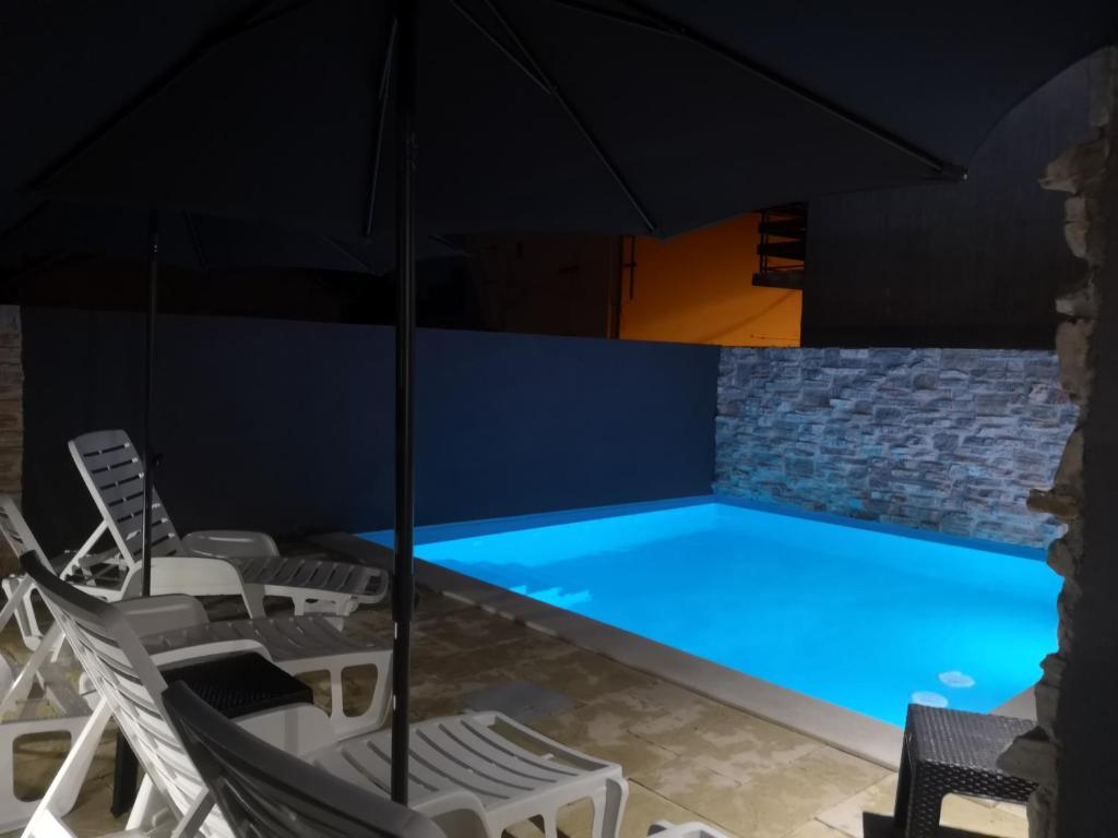 - une piscine avec des chaises et un parasol dans l'établissement Apartment"Tica"Zaton with pool, à Zaton
