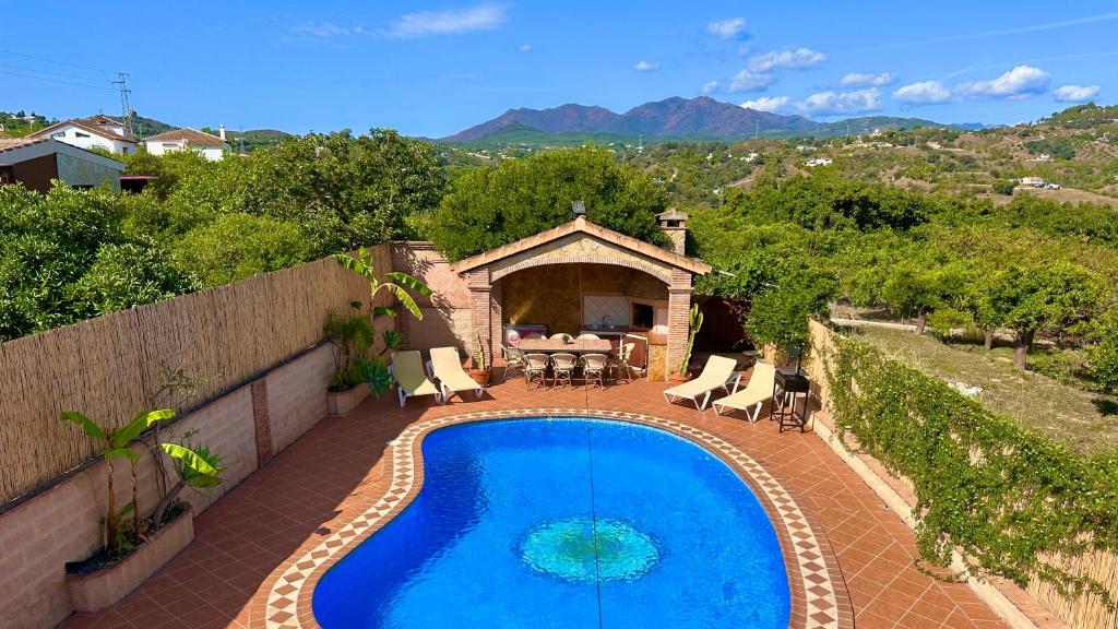 una piscina su un patio con tavolo e sedie di Chalet El Parral - Piscina y Sala de Cine a Málaga