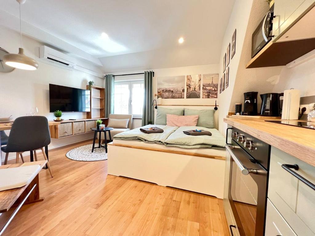um quarto com uma cama num quarto com uma cozinha em Stilvolles Mikroapartment in Kehl Goldscheuer - 1A Guesthouse em Kehl am Rhein