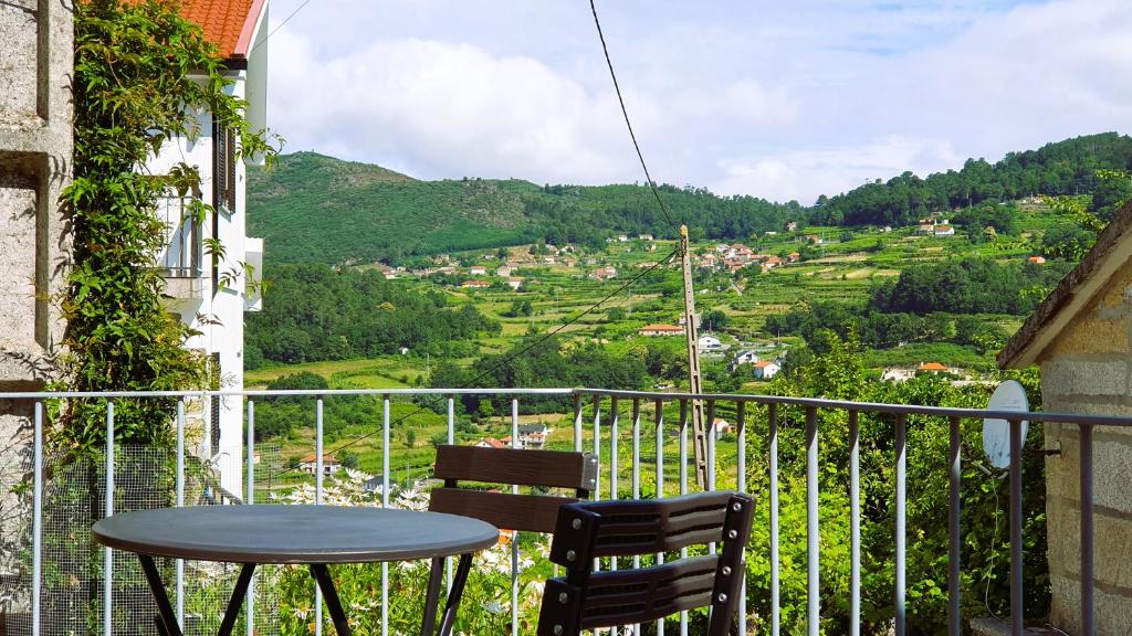 a table and chairs on a balcony with a view at Casa Caminho da Ponte in Monção