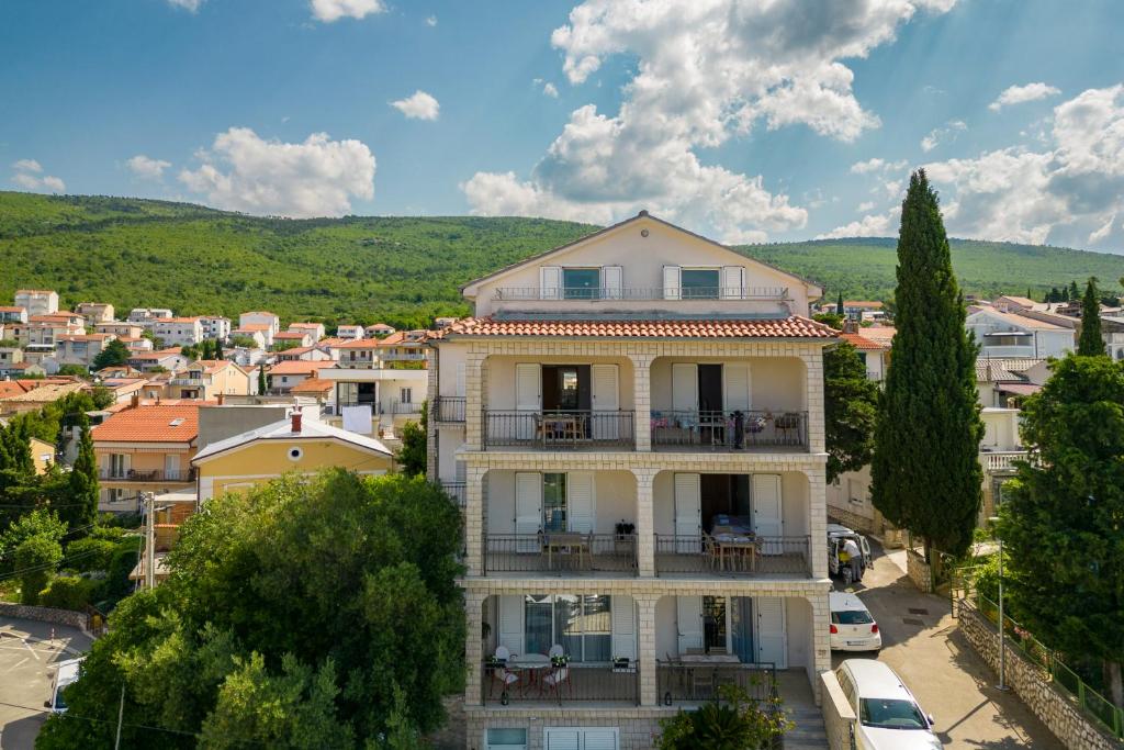 a building with a balcony in a city at Apartments Lonzor I in Selce