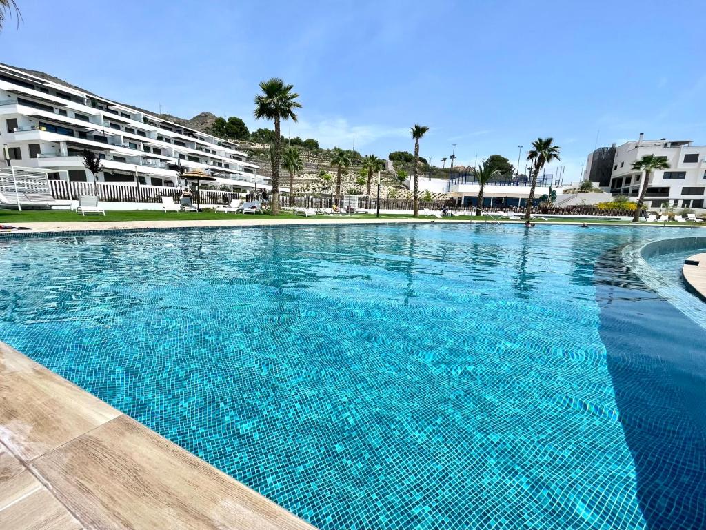 une grande piscine bleue avec des bâtiments en arrière-plan dans l'établissement SEASCAPE LUXURY APARTMENT, à Finestrat