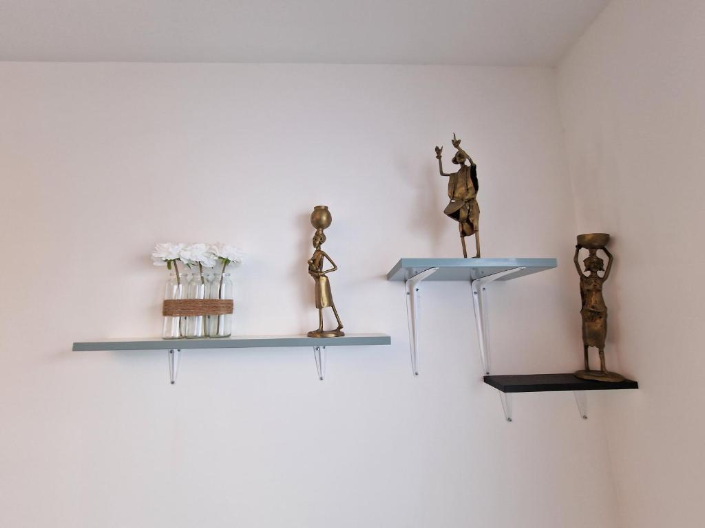 a group of figurines on shelves on a wall at maison PING ,en face des arènes in Béziers