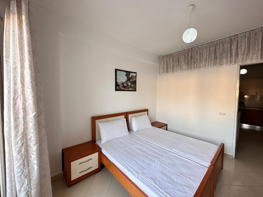 Cette petite chambre comprend un lit avec des draps blancs. dans l'établissement Asa Apartments Lungomare, à Vlorë