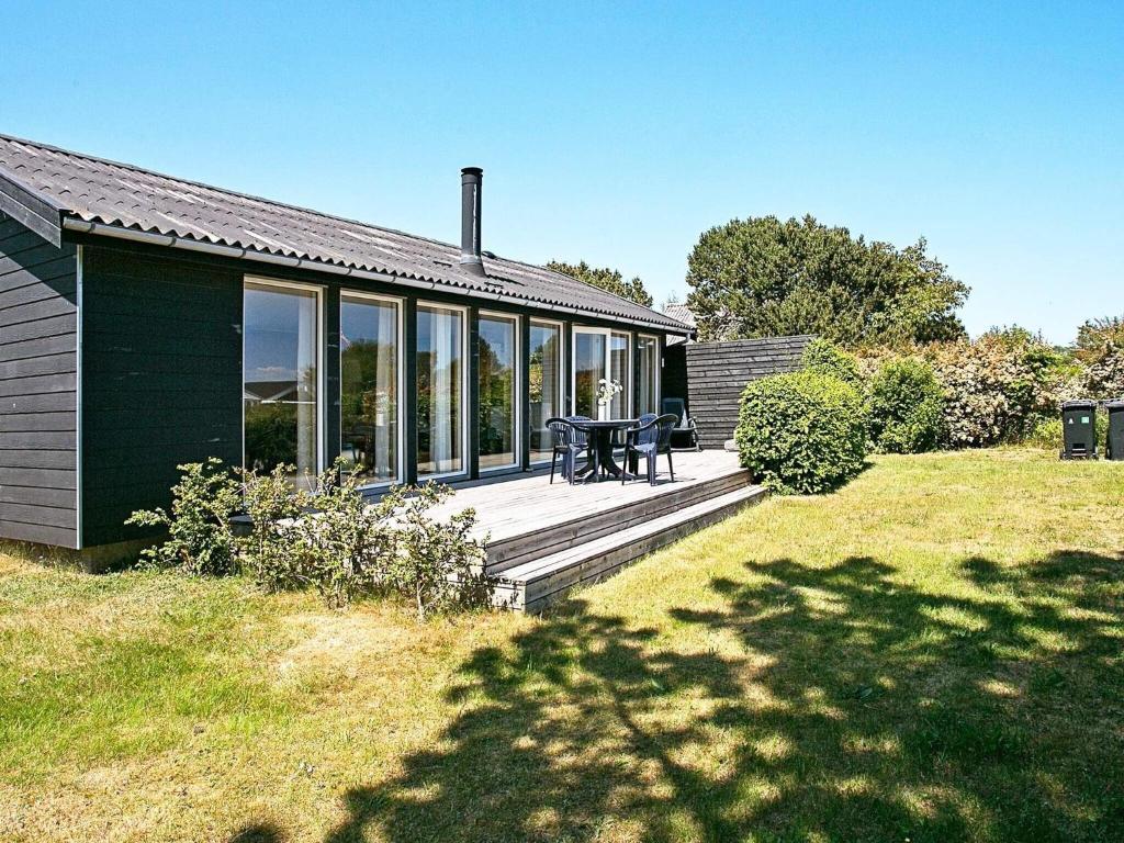 una casa con una terraza con una mesa. en Holiday home Hesselager VII, en Hesselager