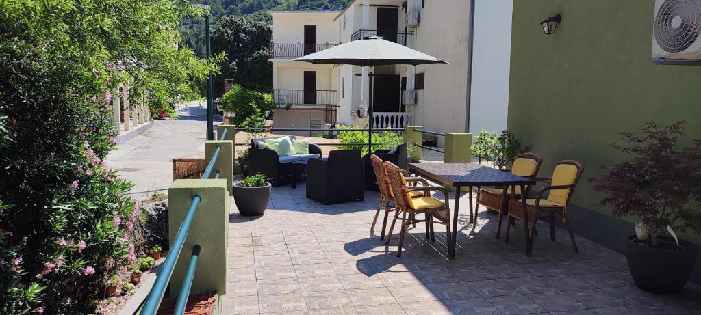 une terrasse avec une table, des chaises et un parasol dans l'établissement Valerie Apartman, à Drvenik