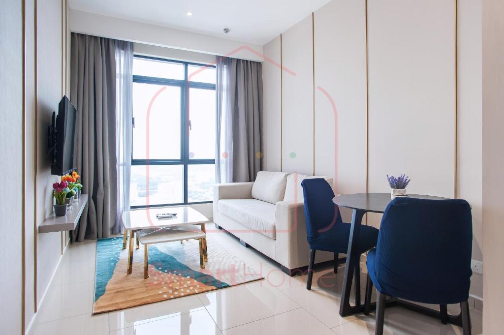 uma sala de estar com um sofá, uma mesa e cadeiras em LUXURY CONDO RM99 HILL10 ICITY 2BD FREE PARKING em Kampong Padang Jawa