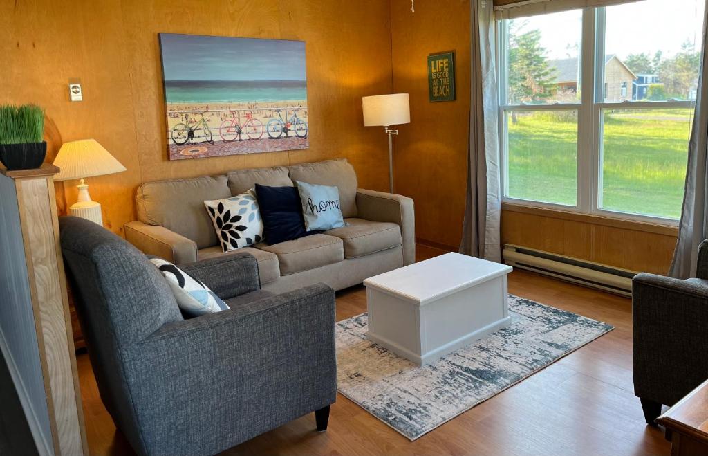 a living room with a couch and a table at Little Haven Cottage an ocean view 2 bedroom cottage in Savage Harbour in Mount Stewart