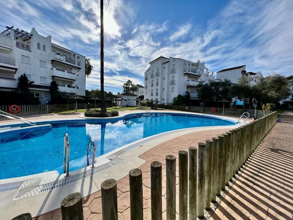 a large blue swimming pool next to some buildings at costa ballena elite in Costa Ballena