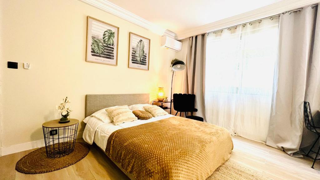 une chambre avec un lit et une grande fenêtre dans l'établissement LE MIRAMAR Nice - Clim, Parking, Wifi et piscine, à Nice